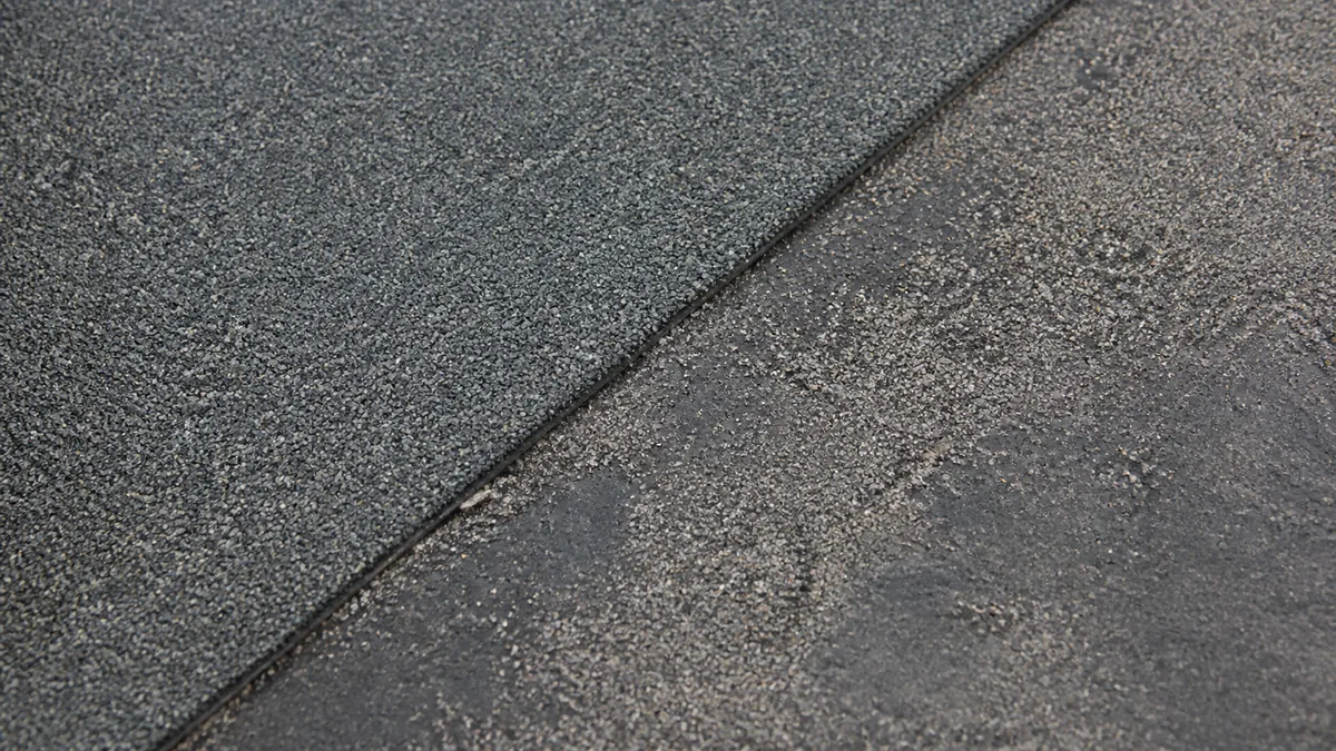 Close view of intact and weathered mineral granules on modified bitumen roofing