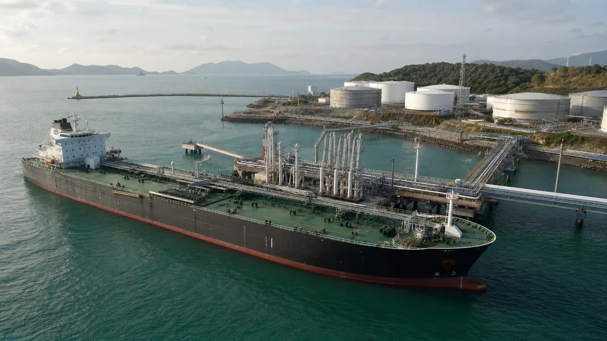 Specialized bulk tanker ship connected to a coastal terminal