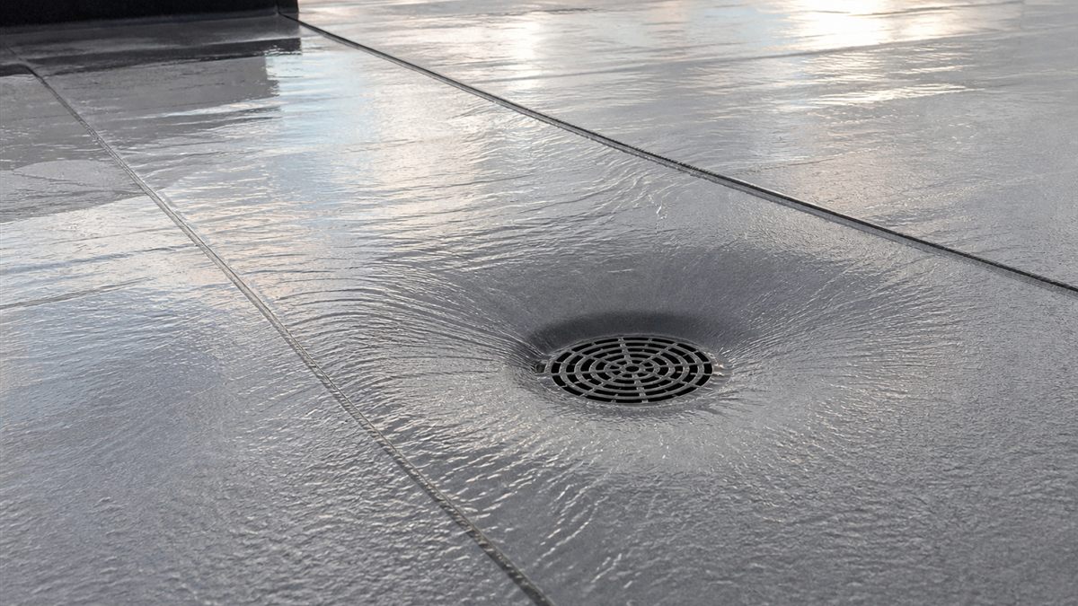 Low-slope modified bitumen roof directing rainwater into a clear drain